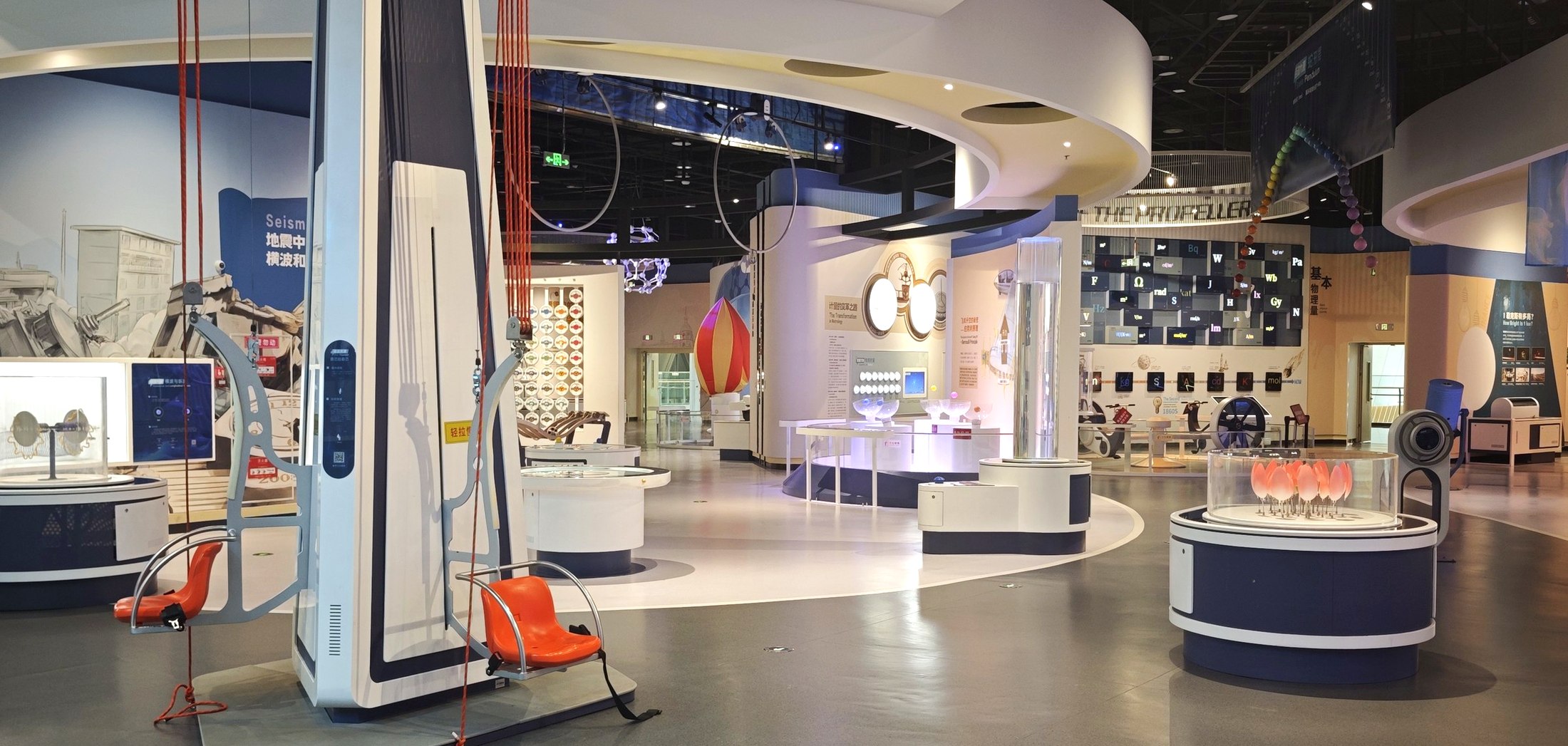 Hands-on mechanics and physics exhibits installed across a science museum floor
